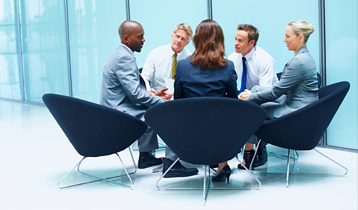 Discussion in modern office with light blue glass background